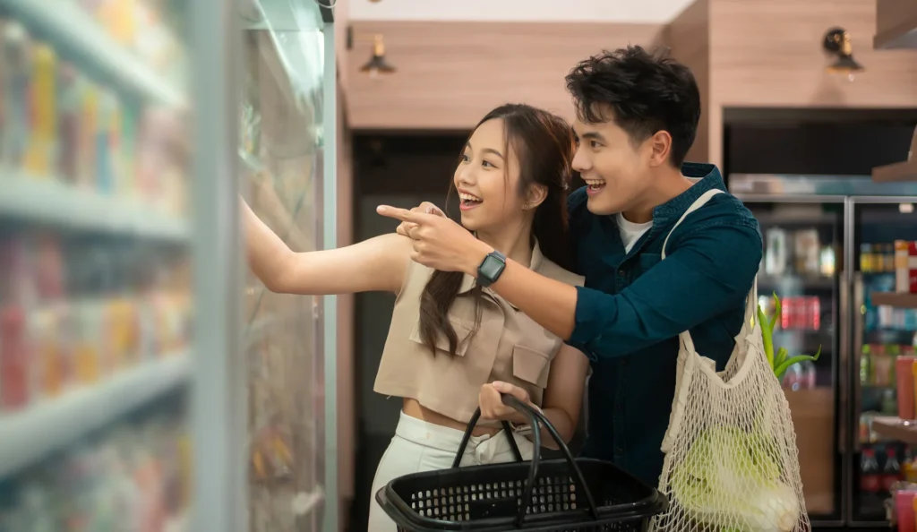 Loving in Promotions - couple looking happily into the supermarket chiller