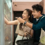 Loving in Promotions - couple looking happily into the supermarket chiller