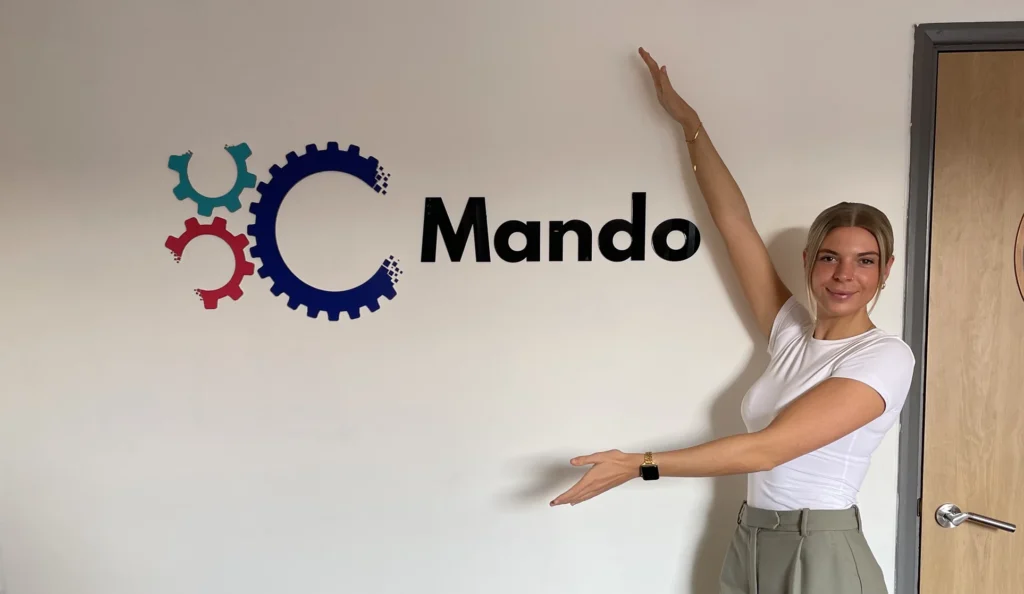 Learnt so far at Mando - Jess outside Mando sign