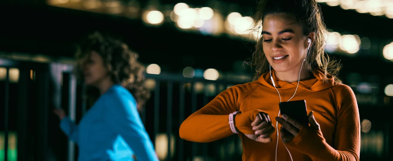 Running brands use Partnerhsips: lady looking at her phone and smart watch