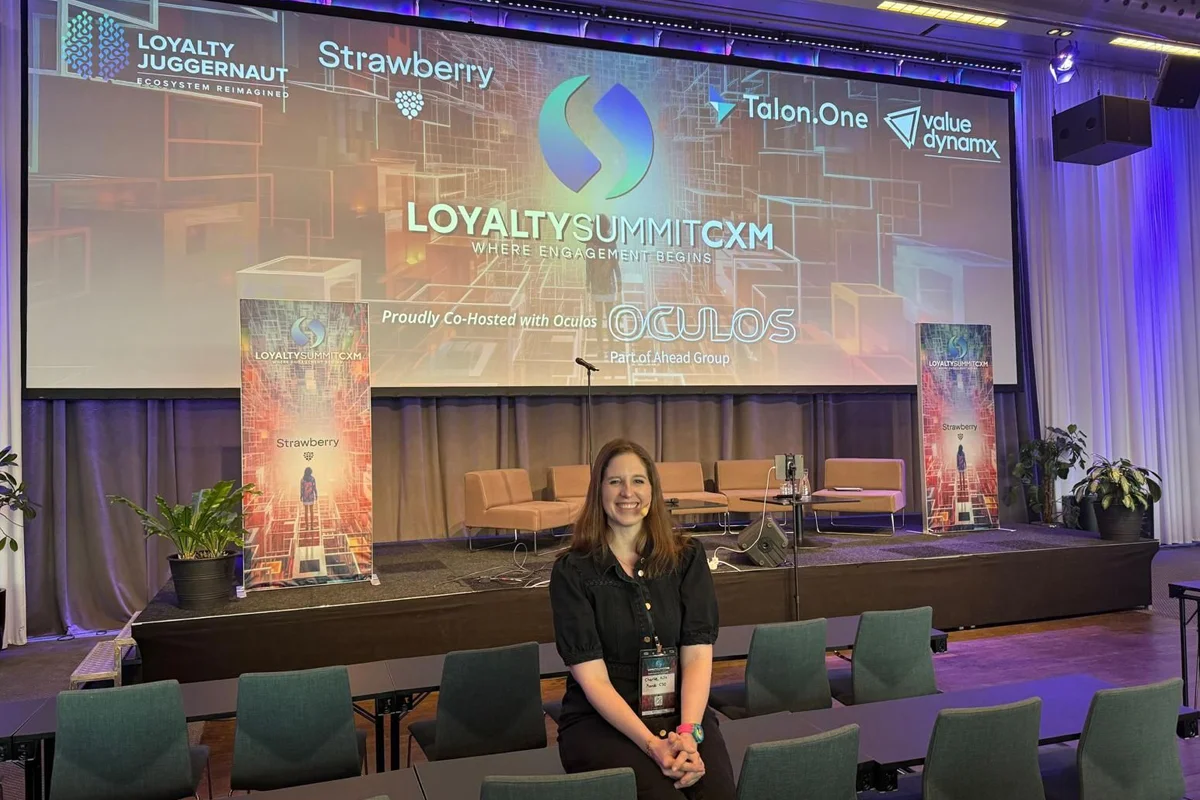 Loyalty Summit CXM: Charlie posing in front of large presenting screen in Stockholm