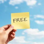 How to Run a “Free” Promotion Without the Risk: A hand holding up a post-it note with the word free on.