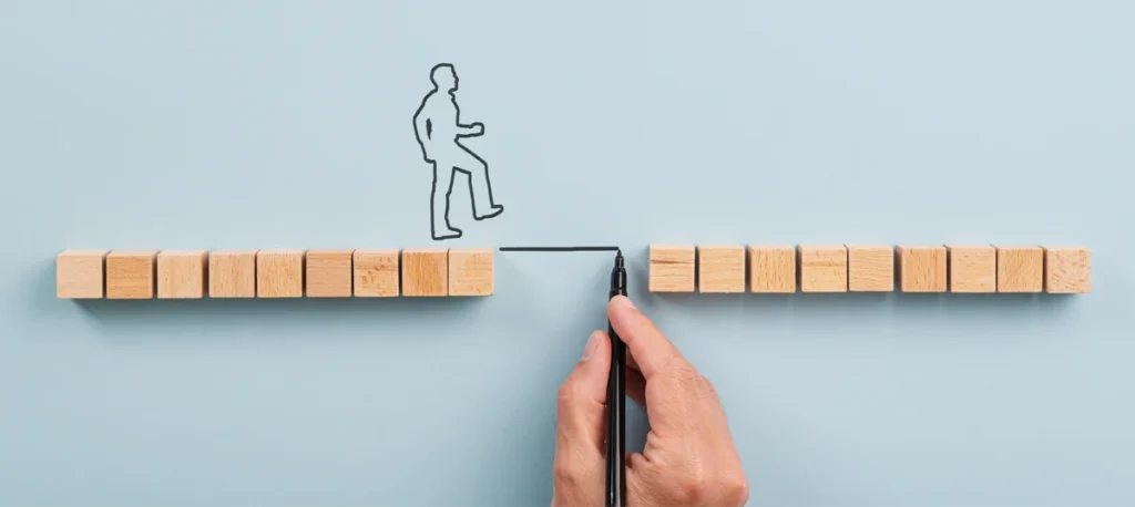 Sales Promotion Examples: wooden blocks with illustrated person walking across a bridge between them
