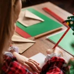 Joy with Royal Mail: child writing a Christmas card with Christmas tree pen