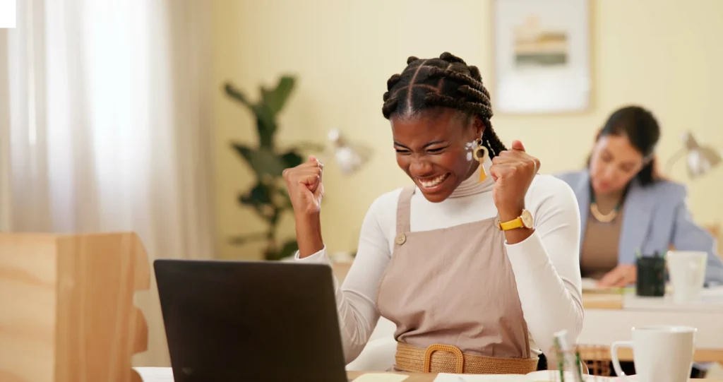 Best Rewards for Consumer Promotions: Lady celebrating at her laptop after winning her reward