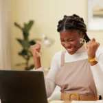 Best Rewards for Consumer Promotions: Lady celebrating at her laptop after winning her reward