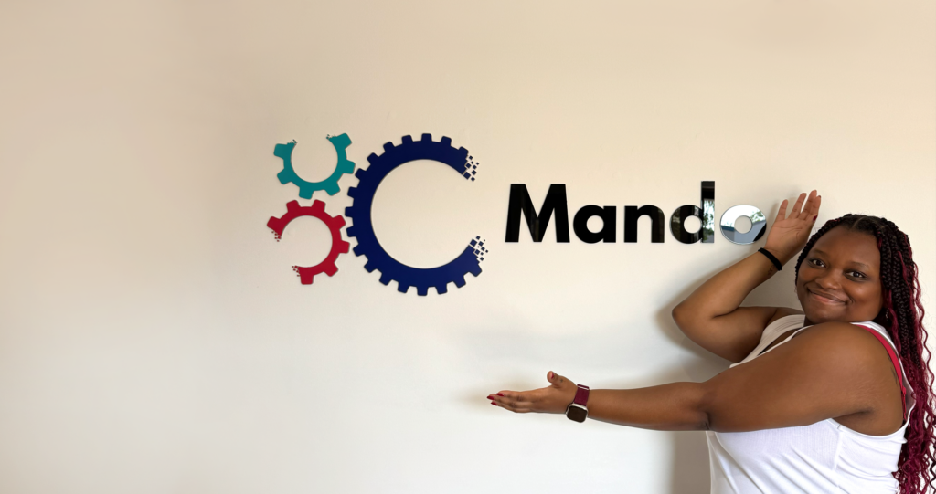 What I've Learnt At Mando: Emilia standing in front of Mando sign in the office