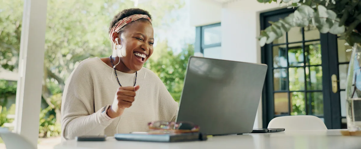 Run a Promotion Online: Lady celebrating on her laptop at home after winning her digital prize